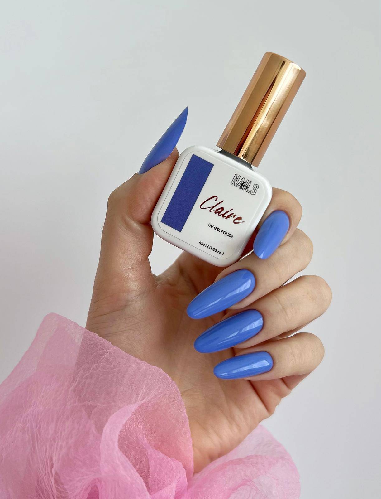 Flacon Gel Polish Claire tenu en main, ongles longs en amande violet bleuté