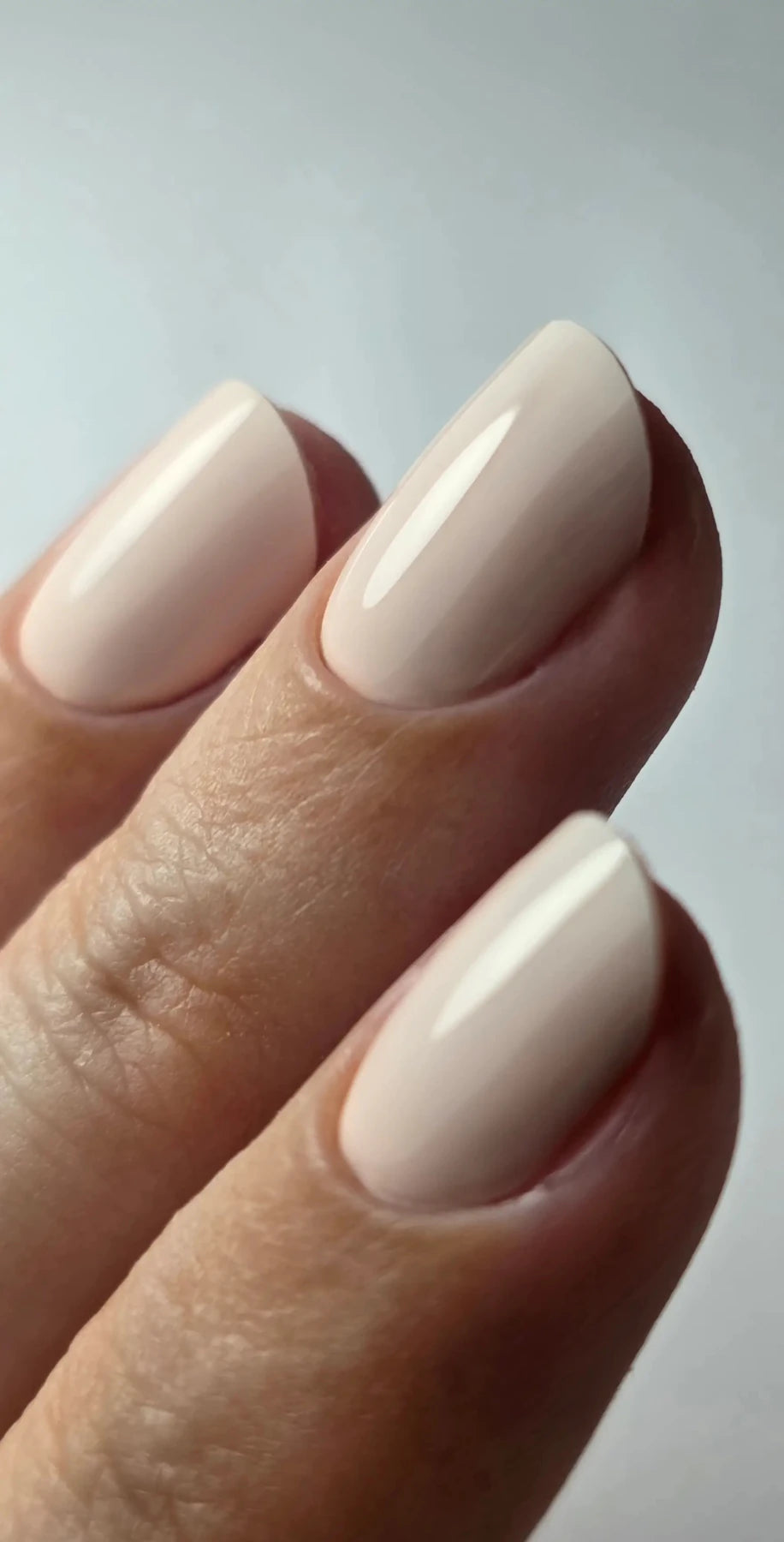 Gros plan du Gel Polish Bride rose ivoire laiteux sur ongles ovales, brillance miroir