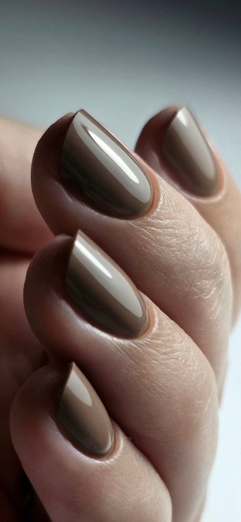 Gros plan du Gel Polish Coffee taupe caramel sur ongles en amande, finition brillante