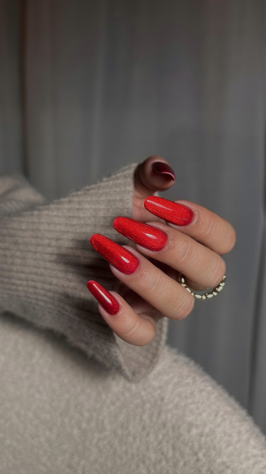 Effet cat eye du Gel Polish Cat Chili, reflet lumineux sur ongles longs rouge feu et bague dorée