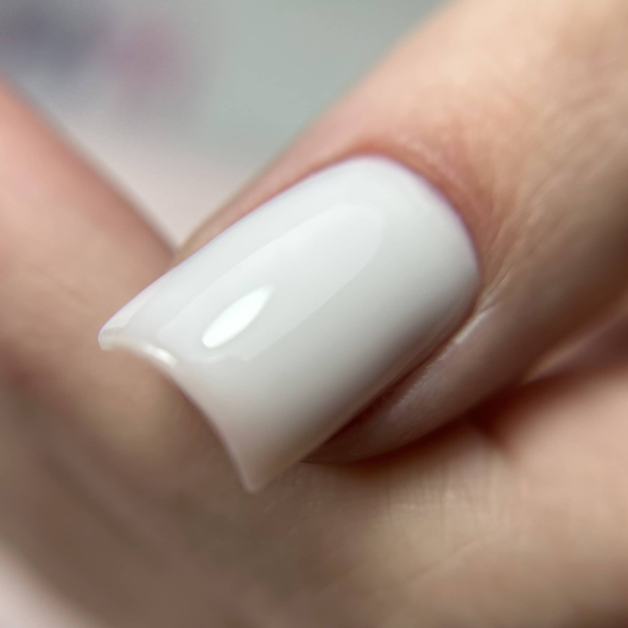 Macro d'un ongle carré gainé au gel Solid fiber milky, blanc laiteux opaque et brillant