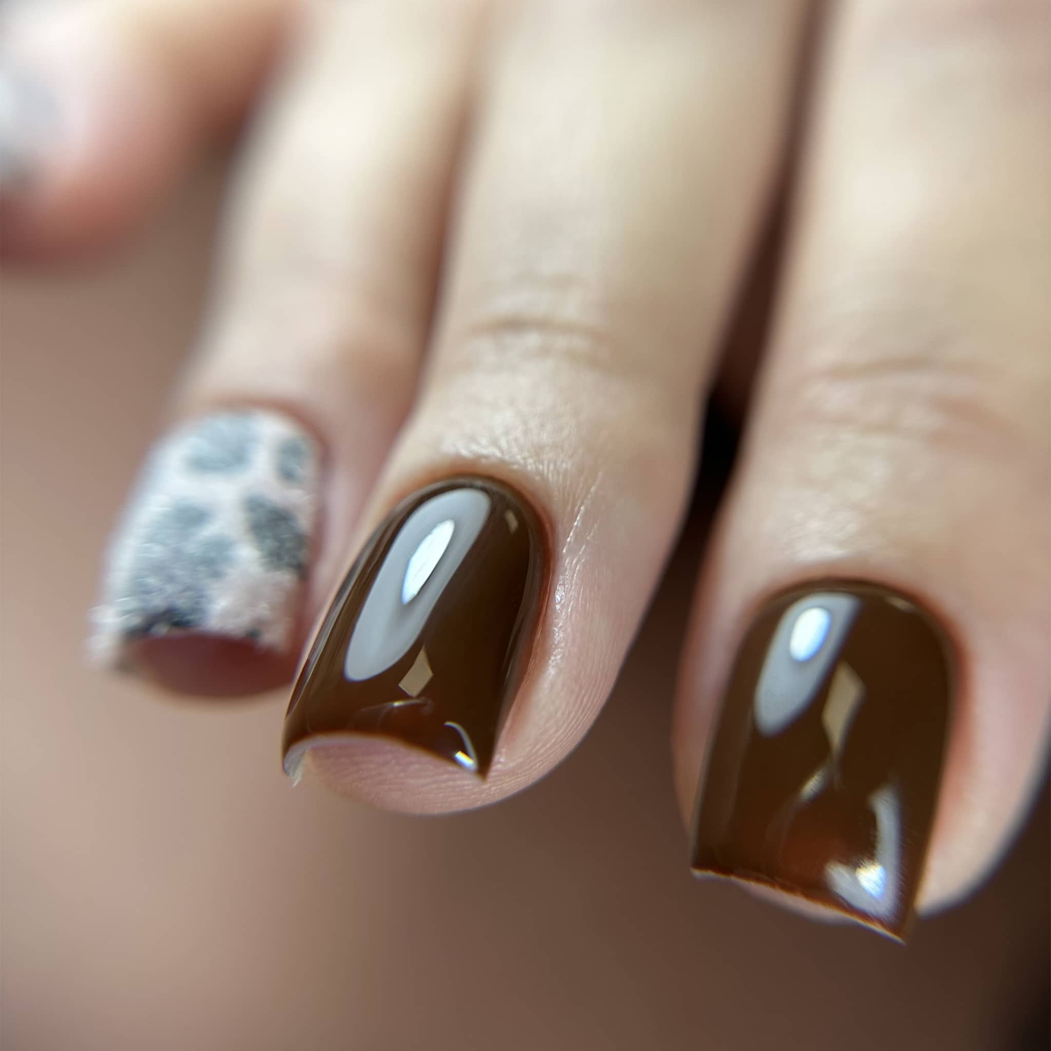Gros plan du Gel Polish Espresso chocolat sur ongles carrés courts, un ongle léopard gris