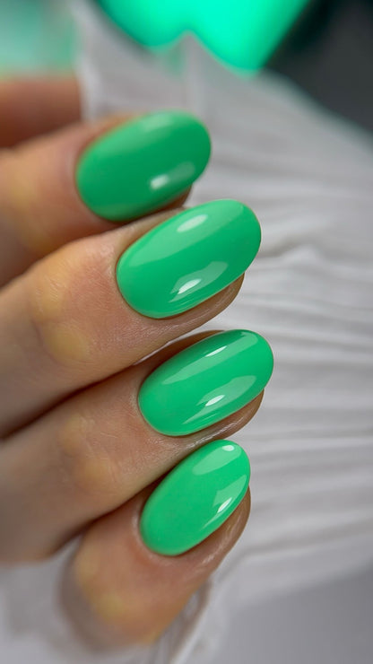 Pose du Gel Polish Palm vert jade sur ongles ovales courts, néon vert en arrière-plan