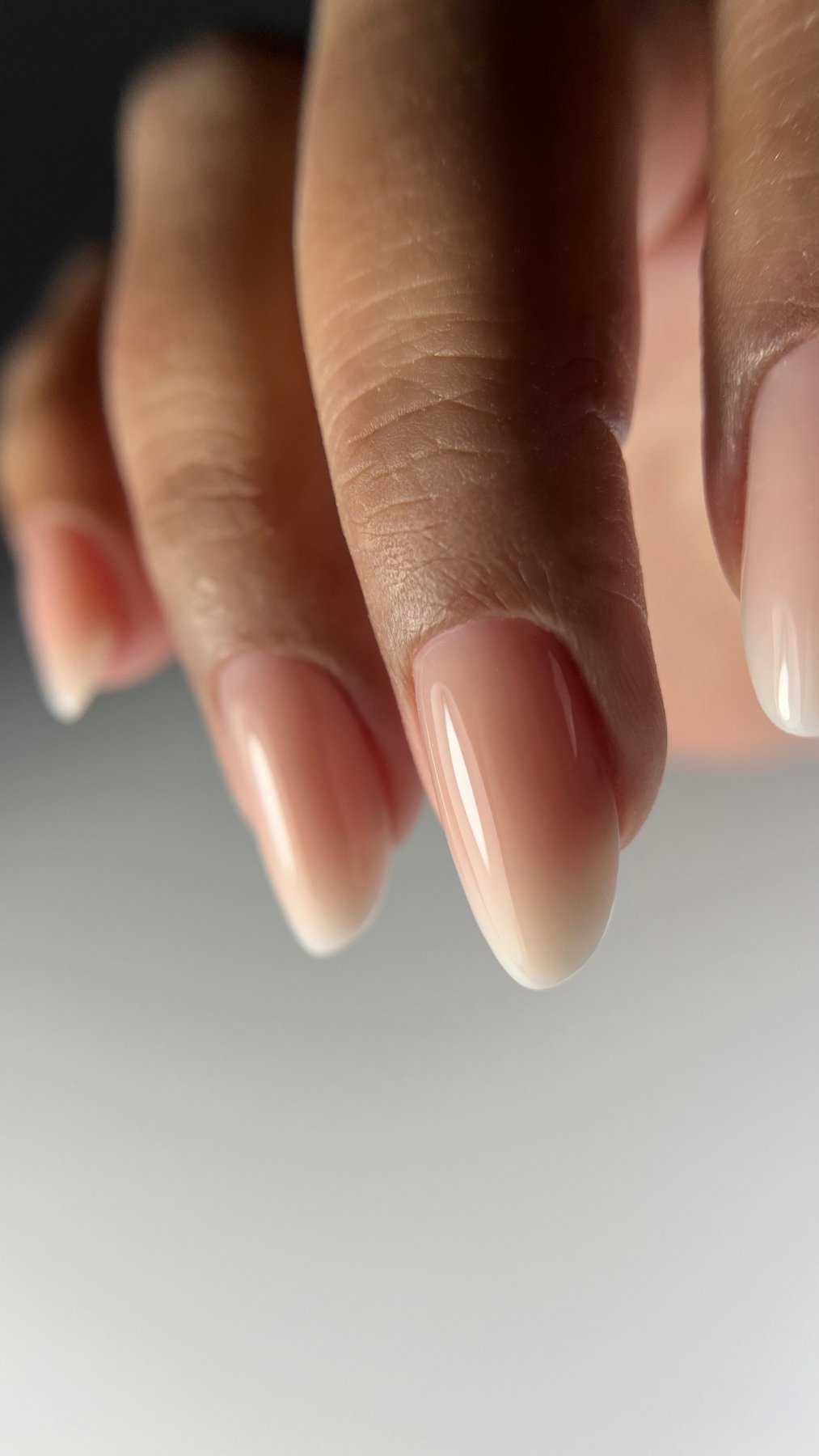 Gros plan de la Cloud base Eden sur ongles amande, dégradé nude rosé translucide