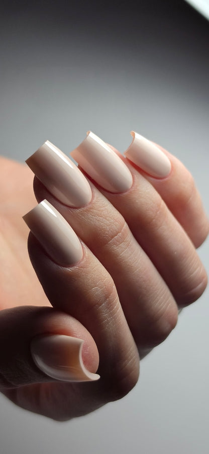 Gel Polish Bride rose ivoire laiteux sur ongles carrés longs, vue de profil sur fond gris