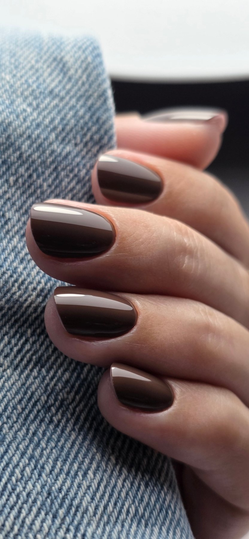 Pose du Gel Polish Mocha chocolat au lait sur ongles ovales, manche en jean clair
