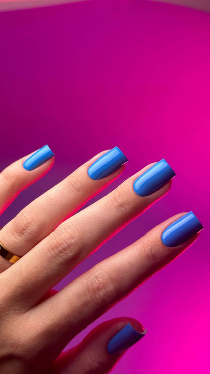 Pose du Gel Polish Friends bleu bleuet sur ongles carrés, fond rose fuchsia