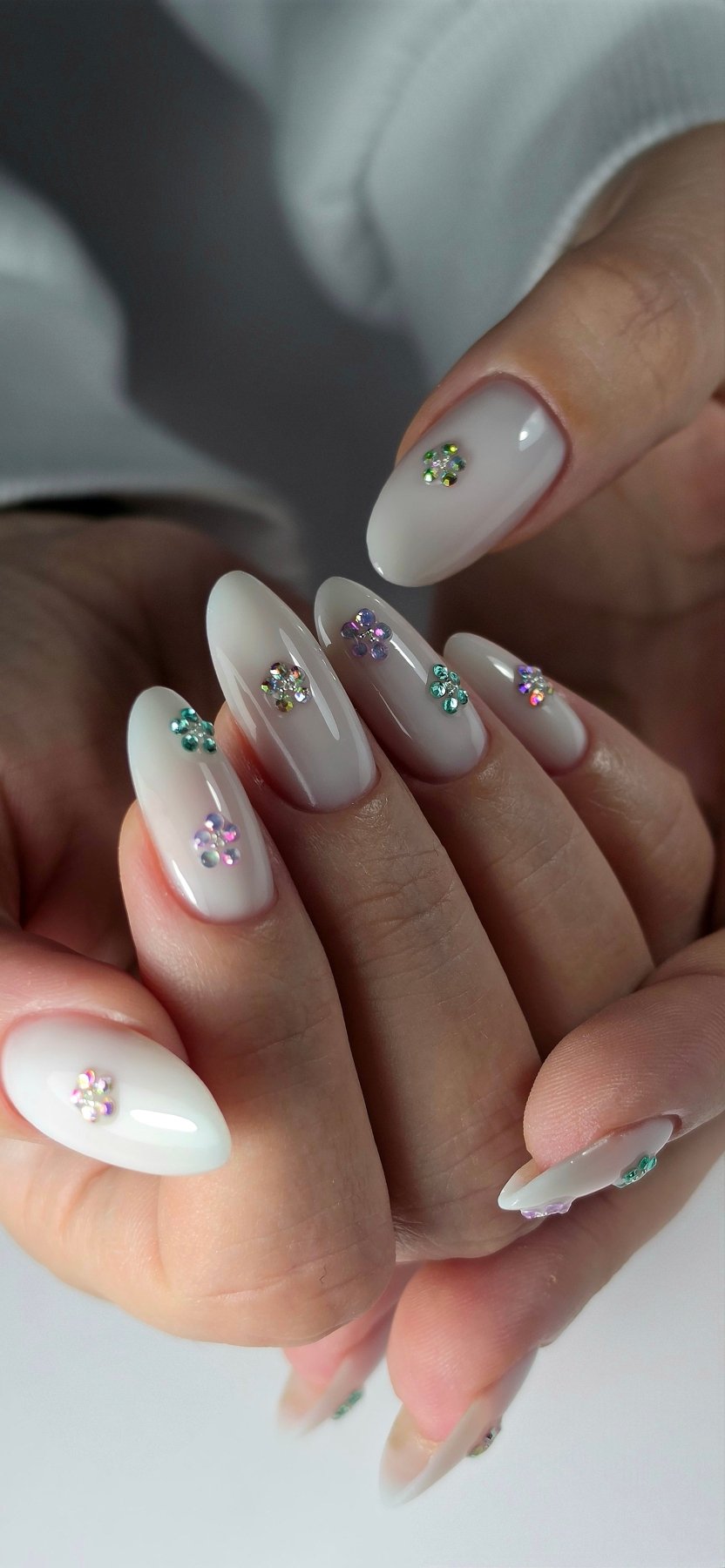 Ongles amande au gel Easy gel Winter, blanc laiteux ornés de fleurs de strass colorées