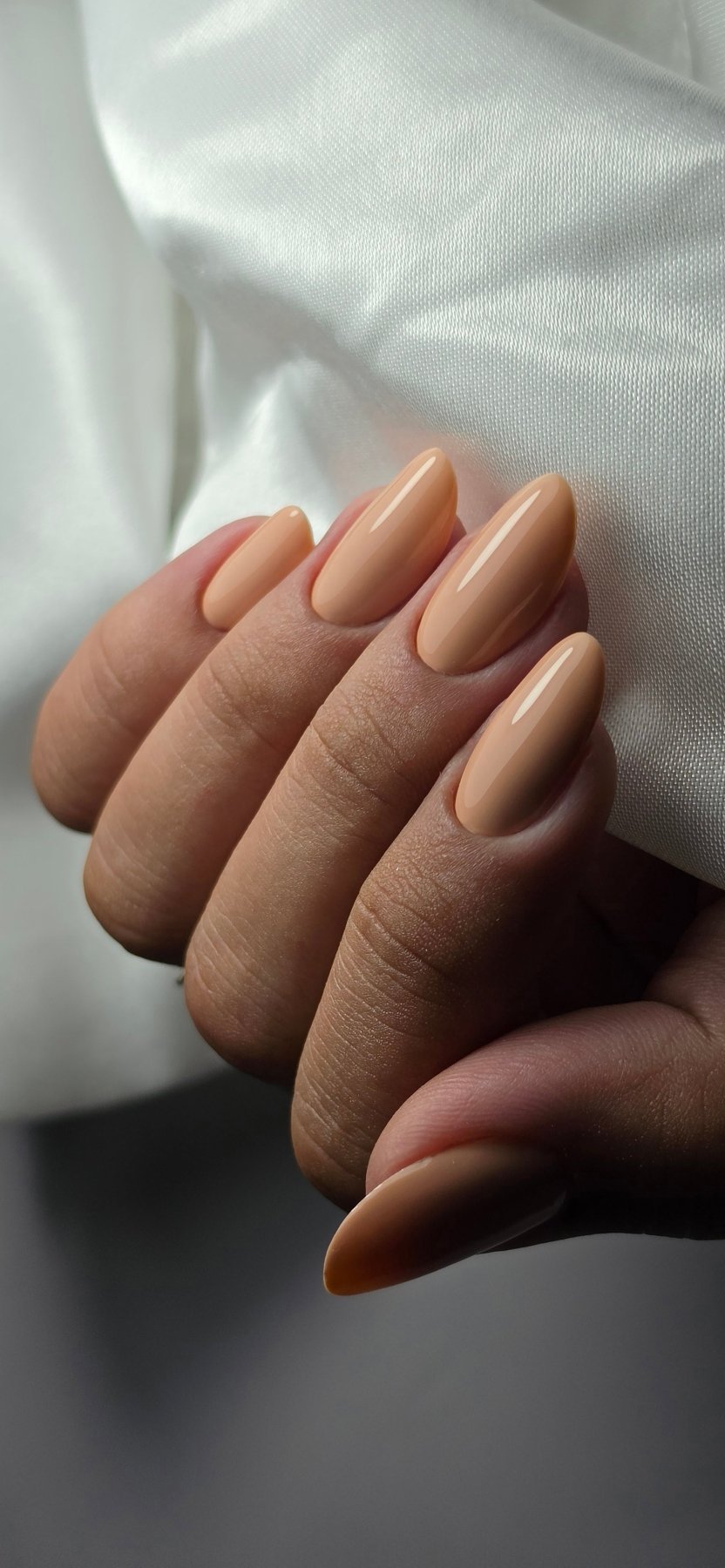 Pose du Gel Polish Married abricot sur ongles en amande, drapé de satin blanc