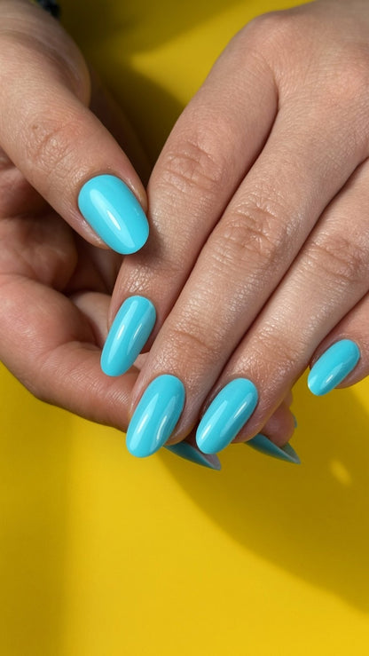 Pose du Gel Polish Copacabana turquoise sur ongles ovales, fond jaune estival