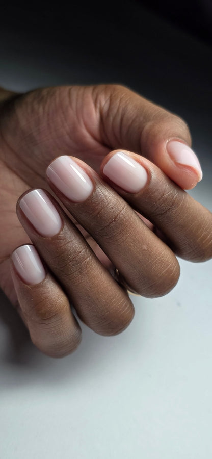 Main sur fond blanc, ongles carrés au gel Solid fiber Vanilla, rose laiteux sur peau foncée