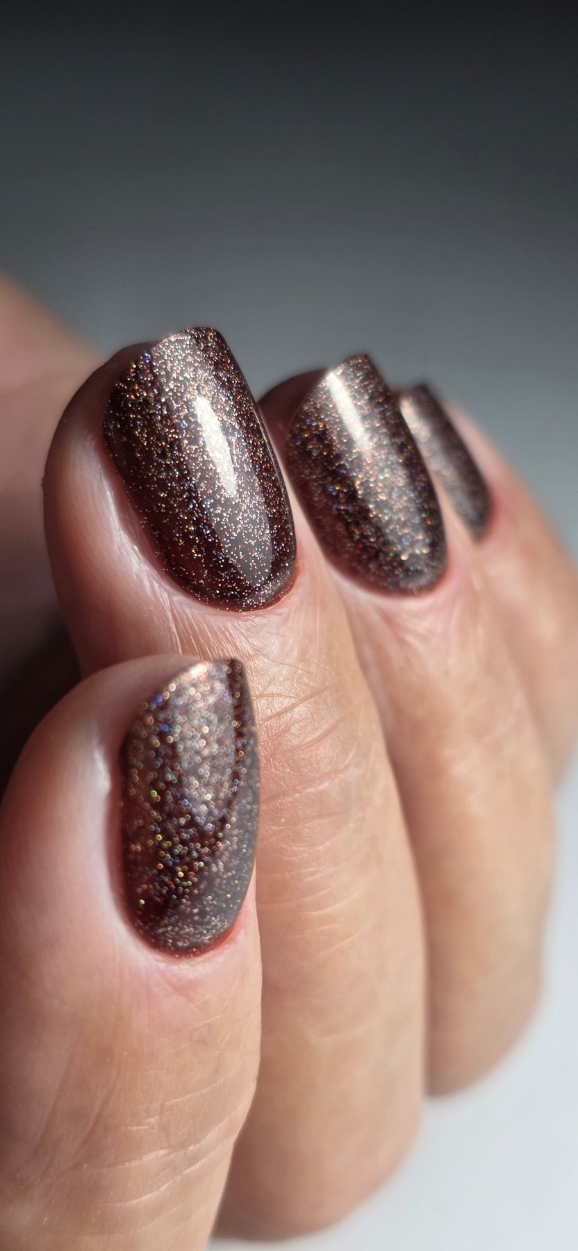 Macro du Gel Polish Brownie, paillettes holographiques sur base chocolat, ongles ovales