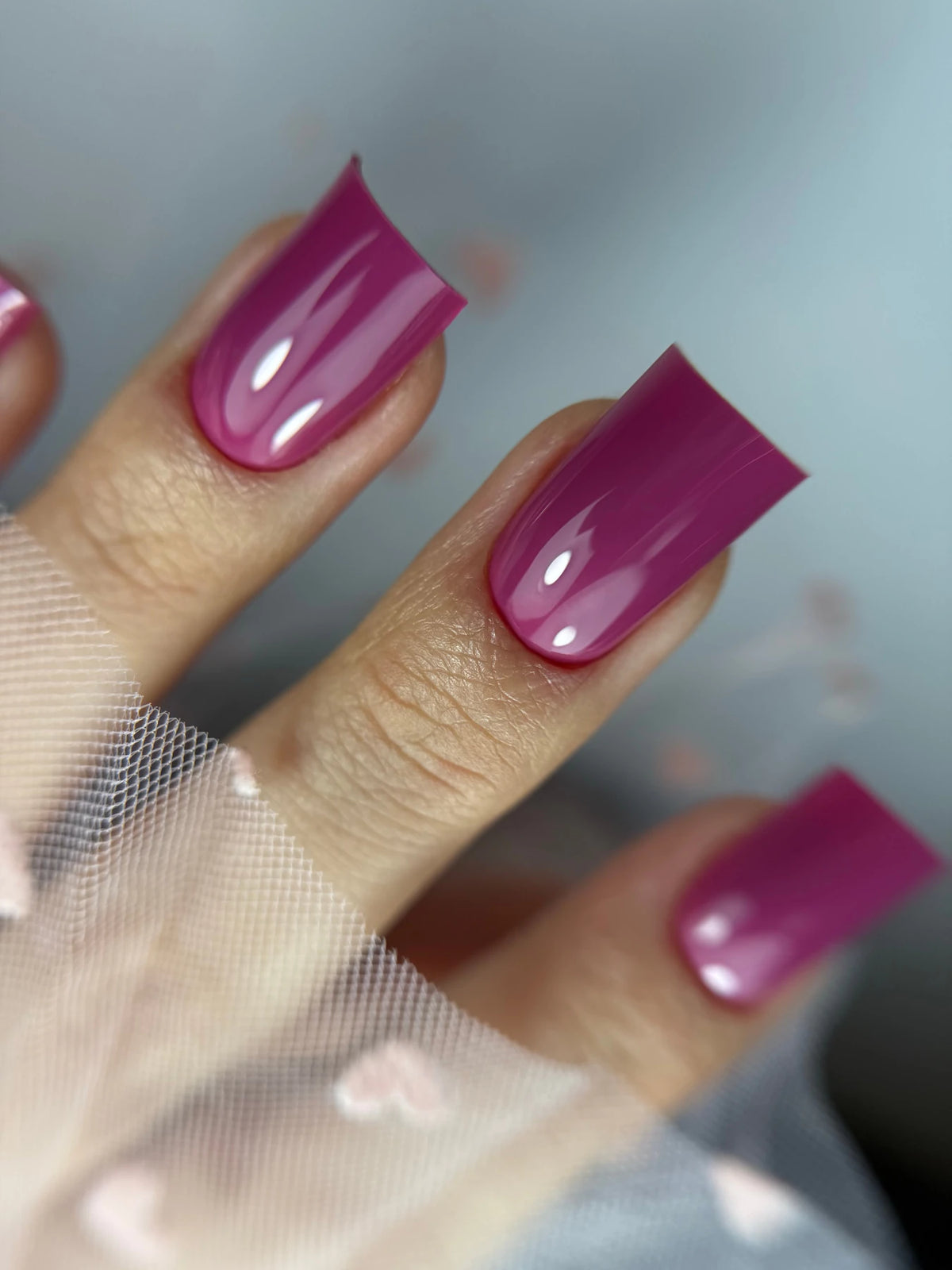 Pose du Gel Polish Baby rose framboise sur ongles carrés longs, fond de tulle brodé