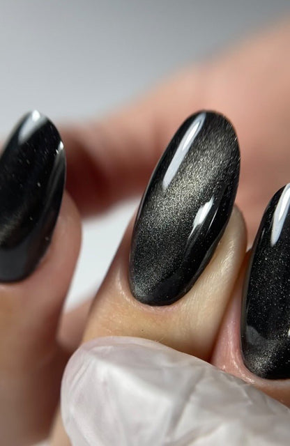 Gros plan de l'effet cat eye du Gel Polish Polar Night, raie argentée sur fond noir