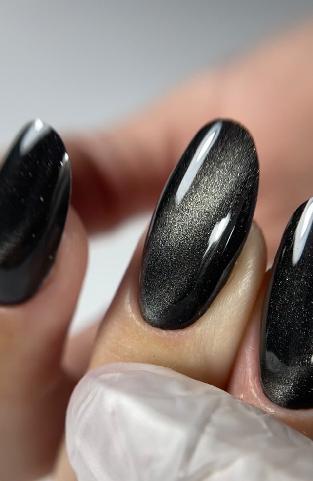 Gros plan de l'effet cat eye du Gel Polish Polar Night, raie argentée sur fond noir