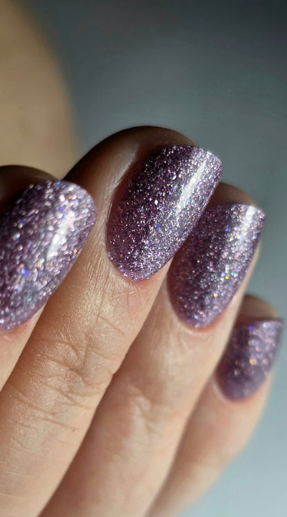 Gros plan du Gel Polish Kitty violet parme sur ongles en amande, paillettes holographiques