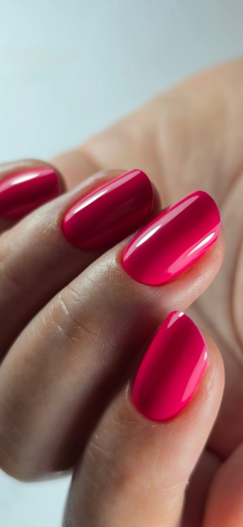 Gros plan du Gel Polish Samba rose magenta sur ongles ovales, finition ultra brillante