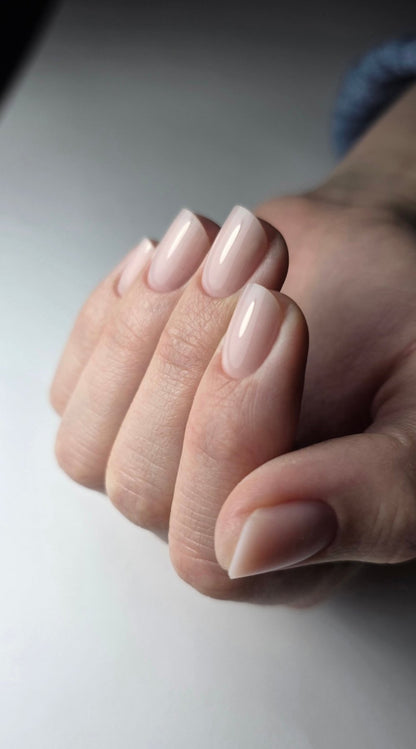 Main fermée aux ongles amande gainés au gel Solid fiber Almond, rendu nude naturel