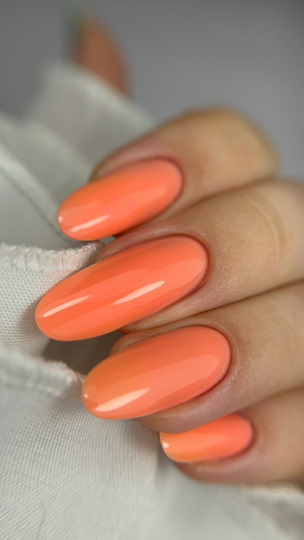 Pose de la Cloud base Malia abricot corail sur ongles amande longs, rendu couvrant