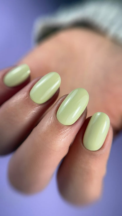 Pose du Gel Polish Dress vert anis pastel sur ongles ovales, fond violet