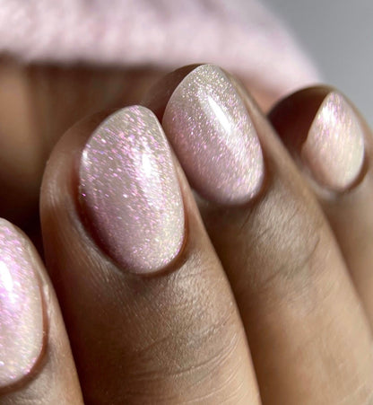 Pose du Gel Polish Pierogi rose nacré irisé sur ongles ovales, fond de pull rose