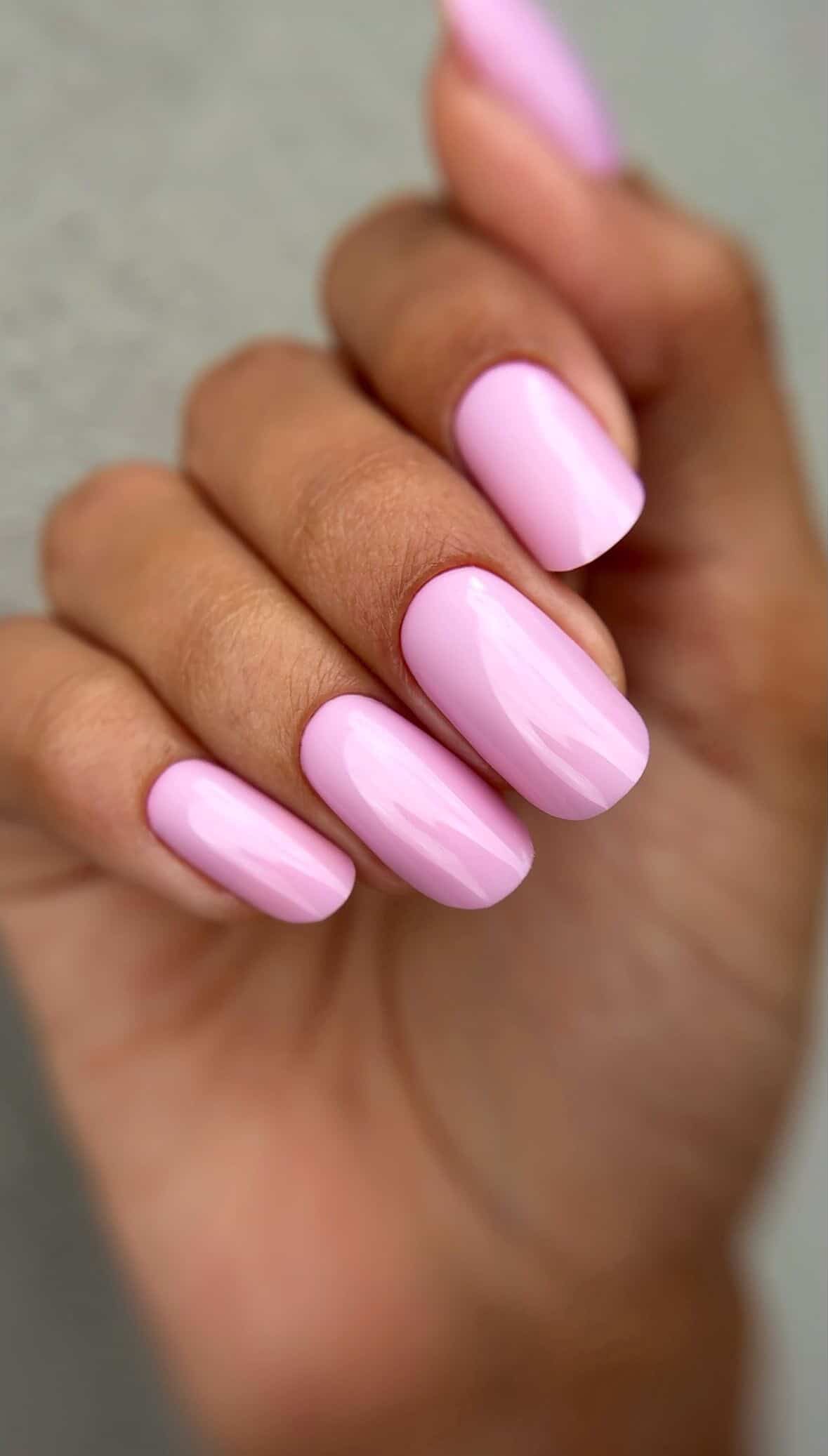 Pose du Gel Polish Forever rose dragée sur ongles carrés arrondis, fond gris clair