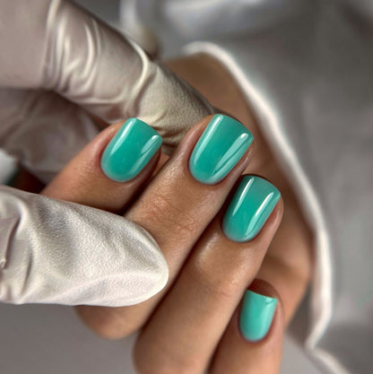 Pose de la Cloud base Noa turquoise sur ongles carrés courts, rendu couvrant brillant