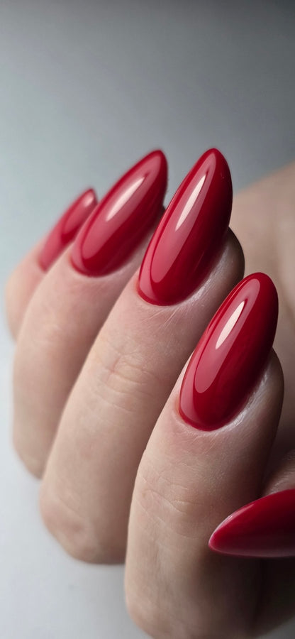 Gros plan du Gel Polish Ruby rouge rubis brillant sur ongles longs en amande