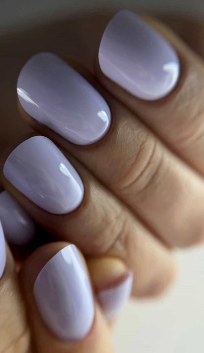 Pose du Gel Polish Besties lilas laiteux sur ongles ovales courts, lumière naturelle