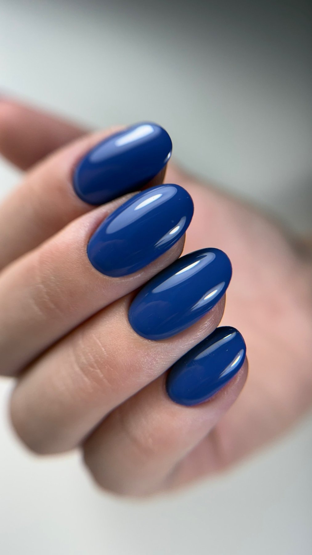 Gros plan de la pose Indigo bleu profond sur ongles ovales