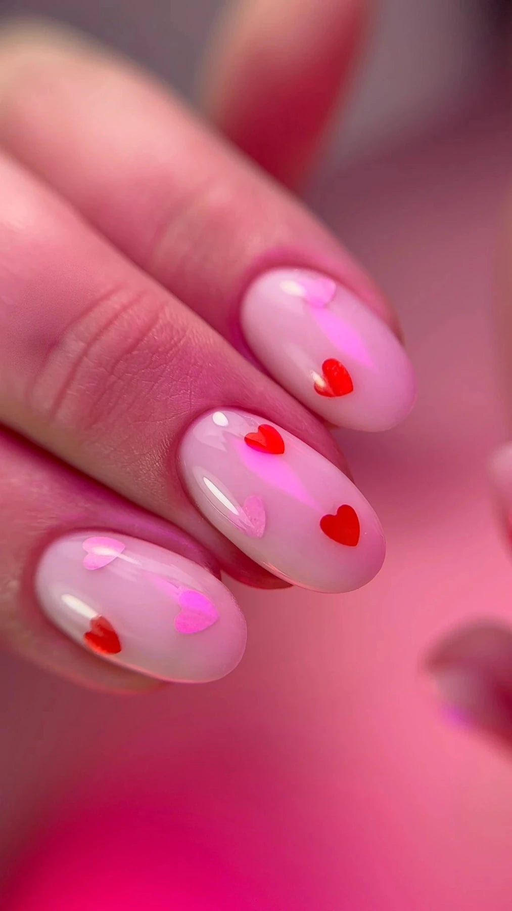 Pose du Gel Polish Kiss, cœurs rouges et roses posés sur ongles ovales rose laiteux