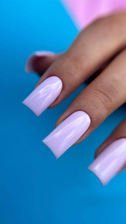 Pose du Gel Polish Camille rose lilas sur ongles carrés longs, fond bleu vif