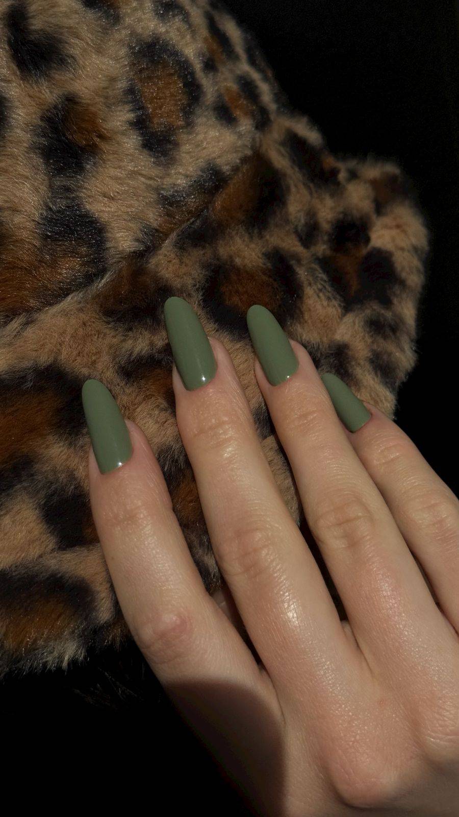 Pose du Gel Polish Jungle vert kaki sur ongles carrés longs posés sur un tissu léopard