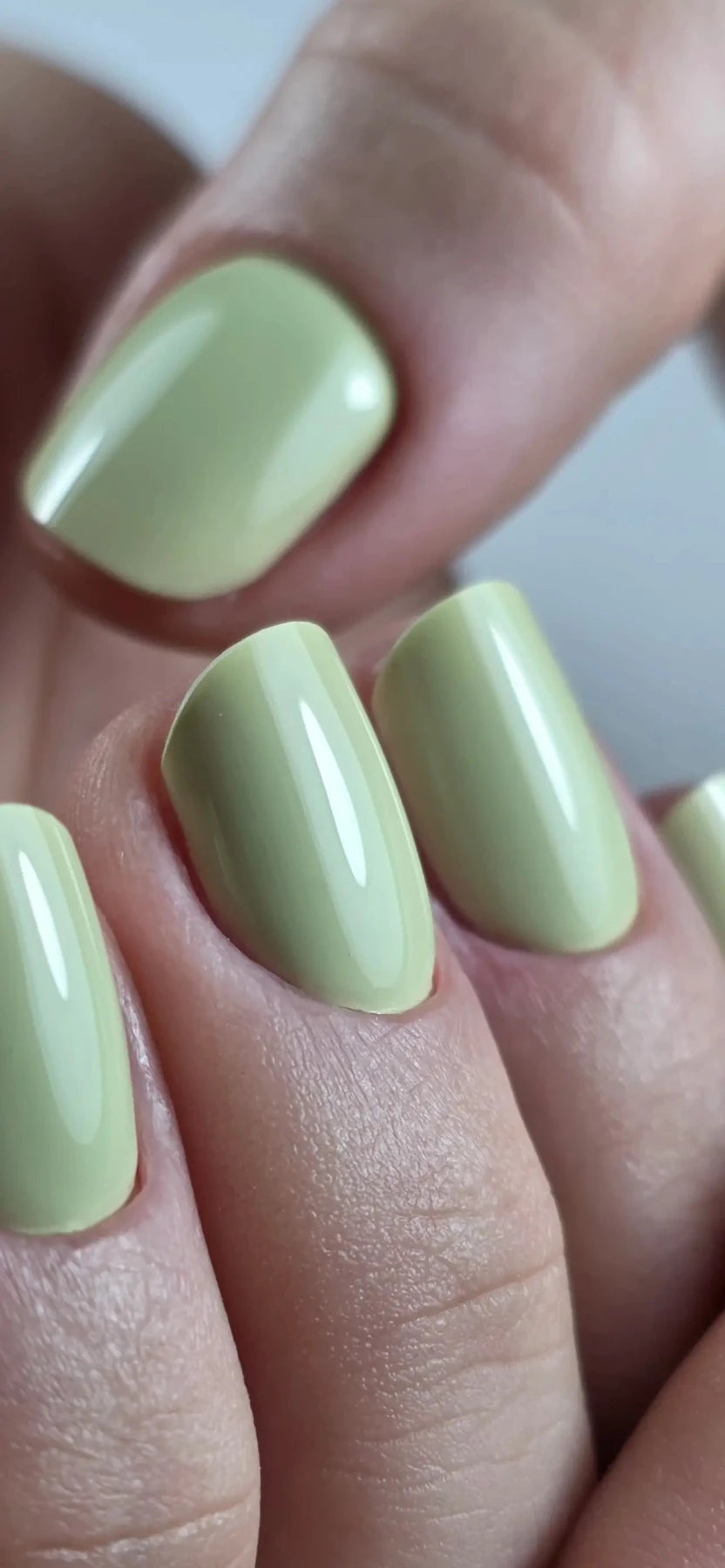 Pose du Gel Polish Dress vert anis sur ongles carrés courts, gros plan des doigts