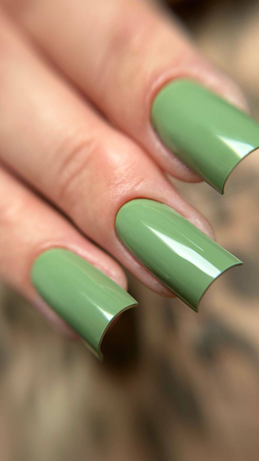 Pose du Gel Polish Tropical vert sauge sur ongles carrés longs, fond léopard flou